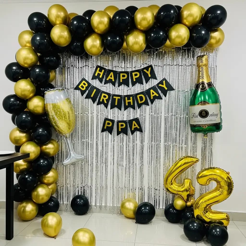 Glitzy black-and-gold birthday décor with a silver fringe backdrop, champagne bottle and glass inflatables, a “HAPPY BIRTHDAY PPA” banner, and shiny gold “50” balloons for a festive celebration vibe.